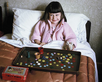 Sally, aged about 4, sat up in bed with a tray of coloured tiddly winks.
