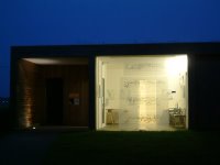 Photograph of Faith House Gallery at night with my drawing installation of 4 acetate landscapes in the gallery window.